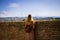 A young blonde woman is looking at the view beyond a brick wall Corinaldo, Marche, Italy