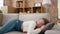 Young blonde woman lying on sofa sleeping at new home