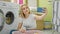 Young blonde woman make selfie by smartphone at laundry room