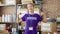 Young blonde woman pointing to volunteer uniform smiling at charity center