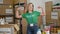 Young blonde woman pointing to volunteer uniform smiling at charity center