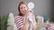 Young blonde woman smelling towel standing at laundry room