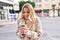 Young blonde woman smiling confident drinking coffee at street