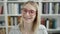 Young blonde woman smiling confident showing braces at library university