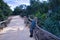 Young blonde woman in sportswear, taking a selfie next to the railing of a wooden bridge. Concept selfie, photo, mobile, curvy