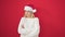 Young blonde woman standing upset wearing christmas hat over isolated red background