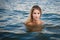 Young blonde woman swimming in ocean with Perfect hair and