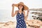 Young blonde woman tourist smiling confident wearing summer hat at beach