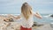 Young blonde woman tourist standing backwards dancing at beach