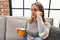 Young blonde woman unhappy drinking coffee at home