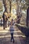 Young blonde woman walking in the street raising her arms