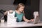 Young blonde woman watching recipe on laptop while cooking lunch in modern kitchen. stand mixer and different ingredients nearby.