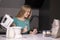 Young blonde woman watching recipe on laptop while cooking lunch in modern kitchen. stand mixer and different ingredients nearby.