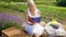 Young blonde woman in white dress reading book in lavender field