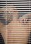 Young Blonde Woman Through Window Blinds