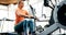 Young blonde woman working on rowing machine