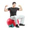 A young bodybuilder sitting on a pilates ball