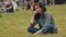 Young bored girl sitting on city park lawn resting face on fist