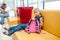 Young boring girl sitting in airport lounge on sofa with her small pink bagpack, kid waiting for a flight