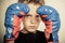 Young boxer holds gloved hands near frowning face