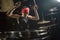 Young boy as rock band drummer . Handsome and cool Asian American teenager in headband playing drum kit performing night music