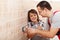 Young boy assisting his father installing electrical wall fixtures