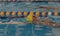 Young Boy in back stroke swim competition breaking surface of pool in water bubble