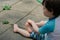 young boy in a bathing suit playing in a puddle of water in the backyard next to a shallow swimming pool