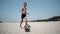 Young boy at the beach plays football ball