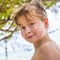 Young boy at the beach is smiling and looking self confident