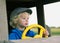 Young boy behind yellow wheel