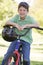 Young boy on bicycle outdoors smiling