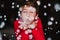 young boy blowing artificial snow flakes at home. Christmas concept