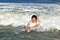 Young boy is body surfing in the waves