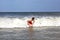 Young boy is body surfing in the waves
