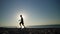 Young boy boxer trains in the morning on the beach with a stone. The boy throws a stone and develops strength