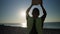 Young boy boxer trains in the morning on the beach with a stone. The boy throws a stone and develops strength