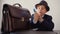 Young boy businessman holding in hands american money stack in business office. Happy boy raising hands with money cash