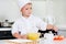 Young boy chef adding ingredients to his bowl