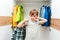 Young boy chooses clothes in the wardrobe closet at home. Cute boy taking school shirt to wear