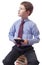 Young boy in classic dress sitting on heap of books with tablet