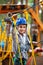 Young boy climbing pass obstacles in rope. Child in forest adventure park