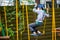 Young boy climbing pass obstacles in rope. Child in forest adventure park