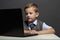 Young boy with computer. funny child looking in notebook