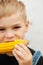 Young boy with corn on the cob in the backyard. A boy happy ab