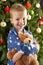 Young Boy Cuddling Teddy Bear In Front Of Tree