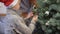 A young boy decorates a Christmas tree
