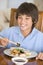 Young boy in dining room eating chinese food