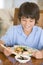 Young boy in dining room eating chinese food