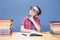 Young boy dreams at the desk in school library